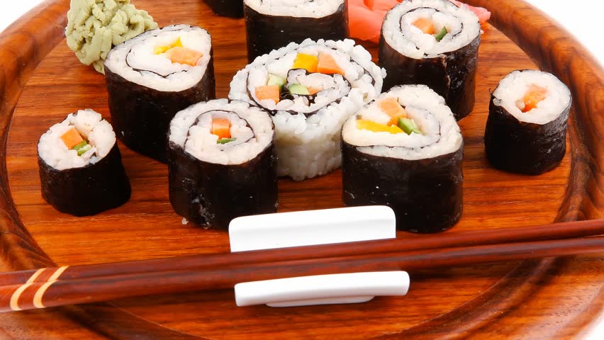 Japanese traditional Cuisine - Roll with Cucumber Cream Cheese with raw Tuna(maguro) and Salmon(sake) inside. on wooden plate with wasabi and ginger isolated over white background