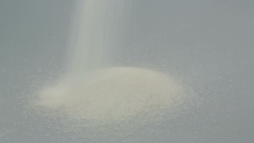 Pile of sugar pouring with sugar lumps and injection on white background for diabetes awareness