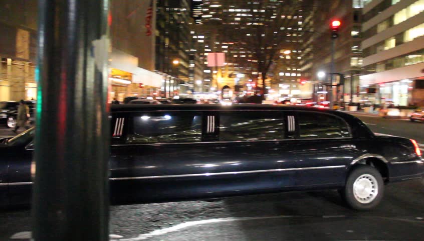 New York, NY - Circa 2012: Multiple Limousines in NYC at night drive the streets looking for customers waiting on the sidewalks