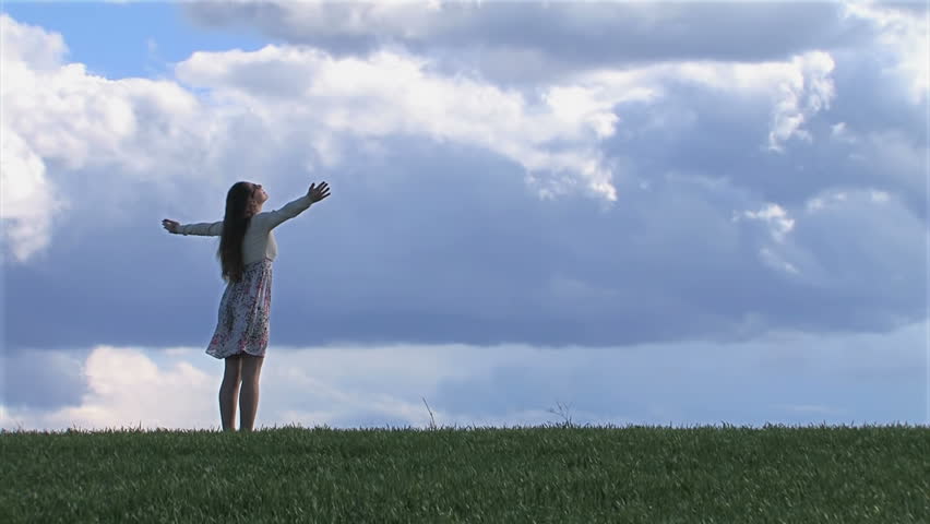 Woman with outstretched hands on a spring field