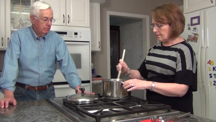 Senior Couple cooking chili together in remodeled white kitchen

