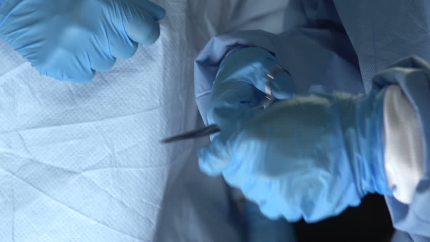 Close up of Assistant handing tools to surgeon 