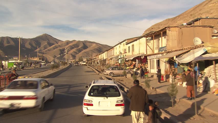 FAYZABAD, AFGHANISTAN - NOVEMBER 18: Traveling shot of crowded street in the center of the northeastern province capital in Afghanistan on November 18, 2011. Vehicles, pedestrians passing by.