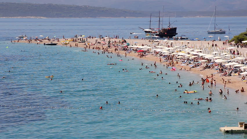 People on the beach, sunbathing and swimming, enjoying on vacation. Famous beach in Bol on Island Brac in Croatia