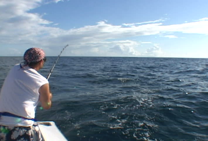 Man in Florida catching King fish from boat.