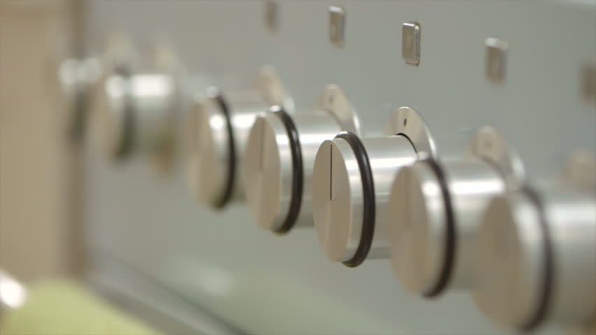 Hand turns knob on stove