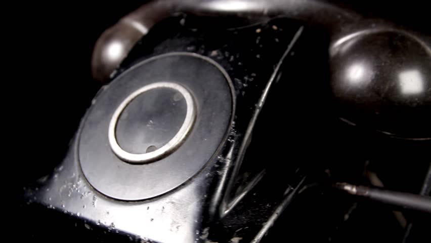 Black Antique Rotary Telephone rotating over black background closeup- looping video