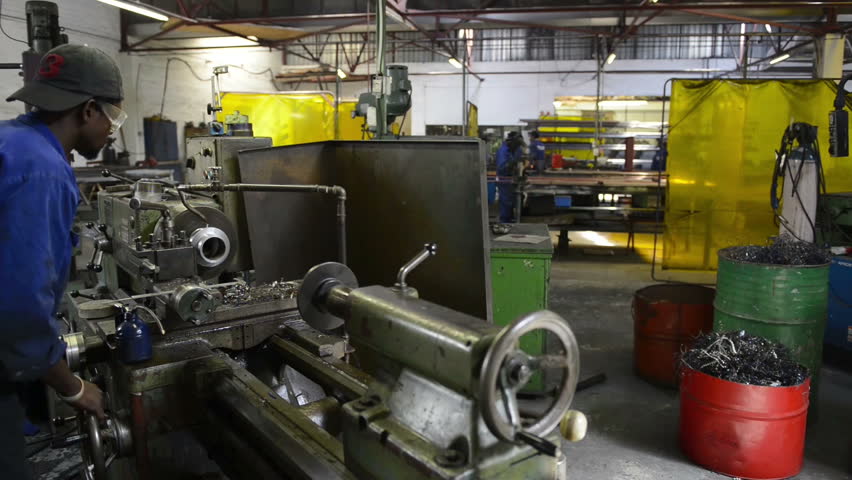 An industrial service repairmen labouring in workshop, selective focus, working on industry machine 