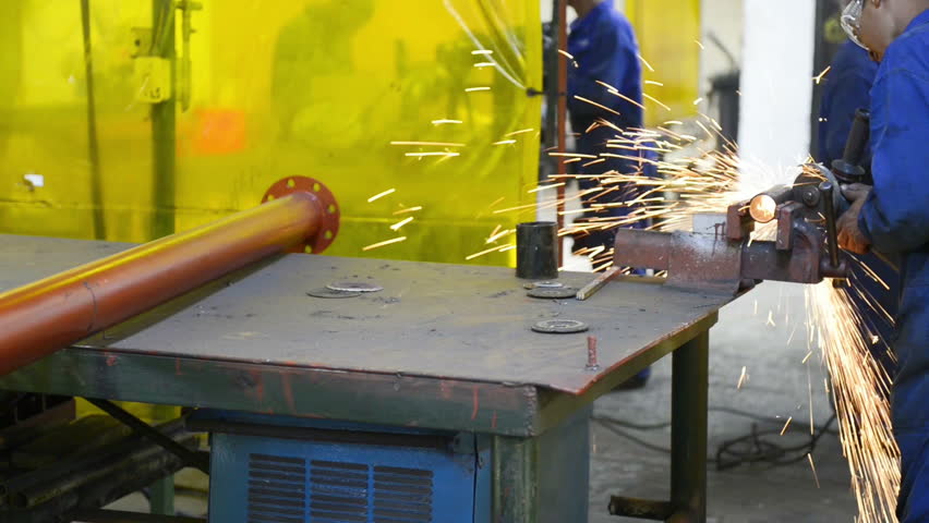 An industrial service repairmen labouring in workshop, selective focus, working on industry machine 