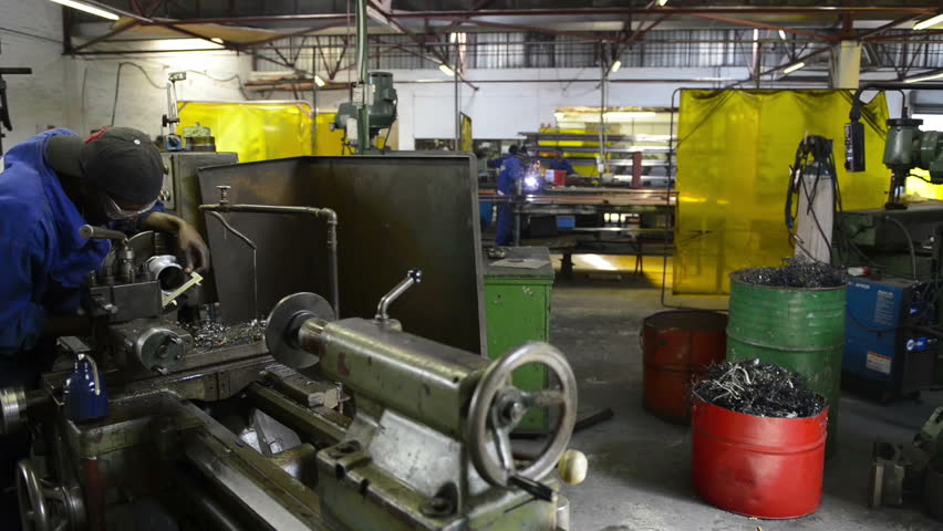 An industrial service repairmen labouring in workshop, selective focus, working on industry machine 