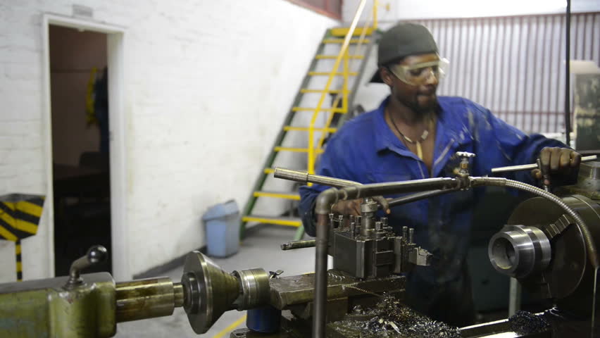 An industrial service repairmen labouring in workshop, selective focus, working on industry machine 