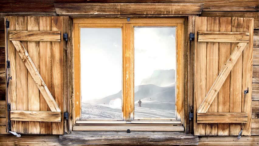 Mountain hut of the alps with skiing scene reflecting in the window
