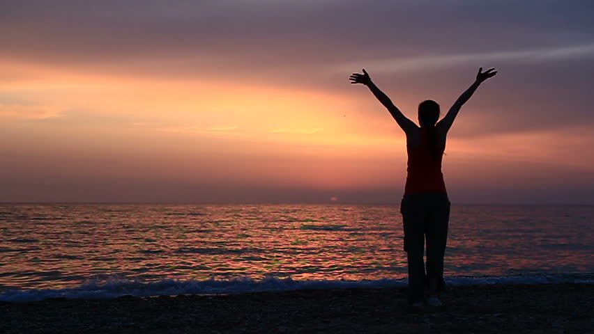 Young woman is waving hands standing on the beach. Slow motion,two frames.