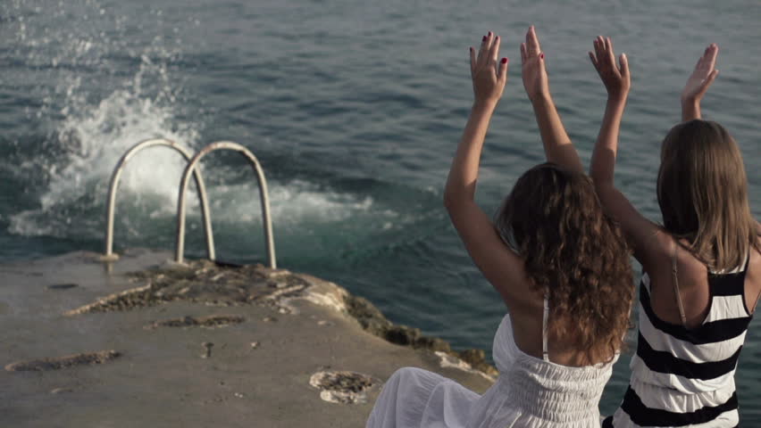 Friends jumping into water with girlfriends applause
