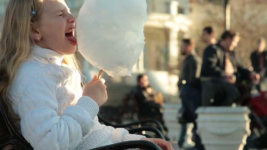 Urban scene - little girl eating cotton candy