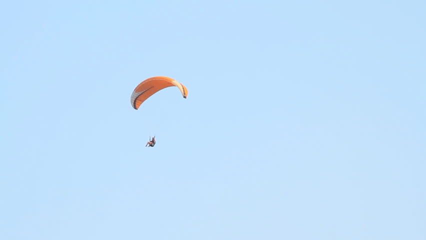 Paragliding over the mountains against clear blue sky