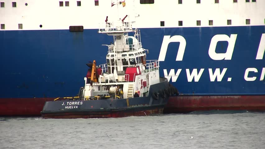 ALICANTE, SPAIN â APRIL 04: The tug "J. TORRES" is working with the general cargo vessel âTELEGHMAâ for entering in the port of Alicante; Spain; on april 04, 2013 in Alicante.
