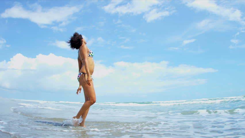 Pretty girl in bikini reveling being alone in ocean on beach vacation shot on RED EPIC