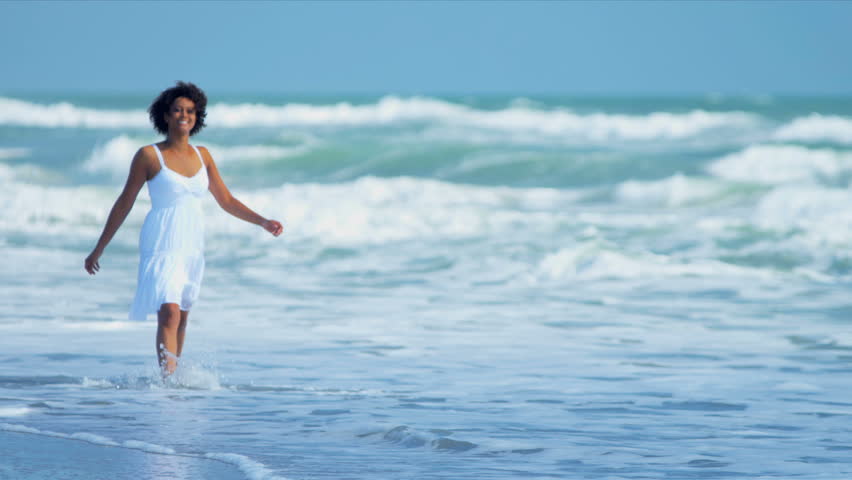Pretty girl in sundress reveling being alone in ocean on beach vacation shot on RED EPIC