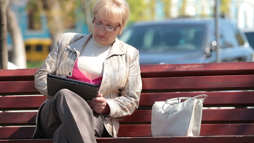 Active senior woman using digital tablet outdoors