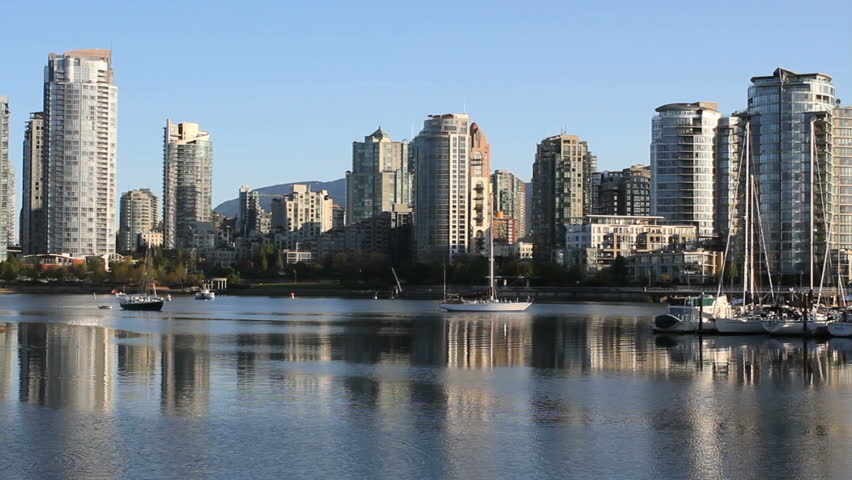 Vancouver Morning, False Creek, Yaletown. A small, commuter passenger ferry in False Creek, passes in front of the apartment buildings and condominiums in downtown Vancouver's Yaletown neighbourhood.