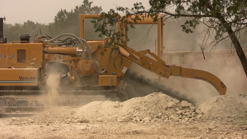 Video closeup of large industrial ditch digger.  Construction Texas. Chain digger with side discharge. Dirt, dust and extreme noise. Home construction development area. Don Despain of Rekindle photo