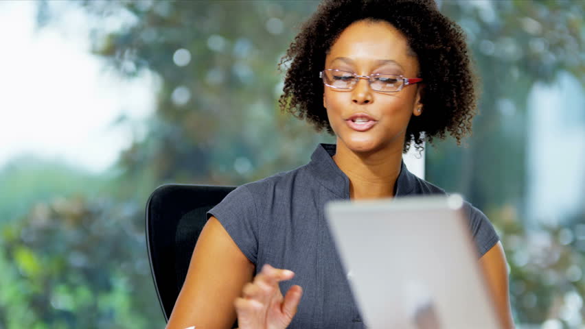 Portrait young female African American financial director talking with colleagues in business meeting shot on RED EPIC