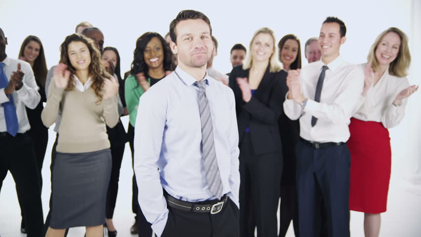 Portrait of a group of happy and diverse business people who are together, isolated on white in a studio shot. One man stands at the front and the rest of his team stand behind applauding his success.