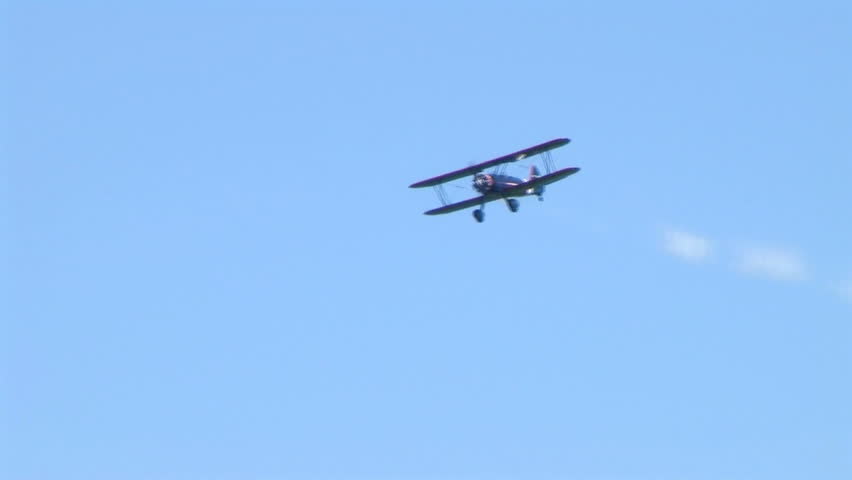 Biplane releasing trail of smoke during exhibition. 