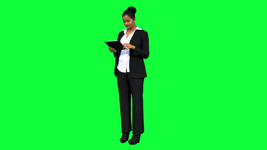 Young Asian Indian female businesswoman with wireless tablet and green screen in virtual business environment