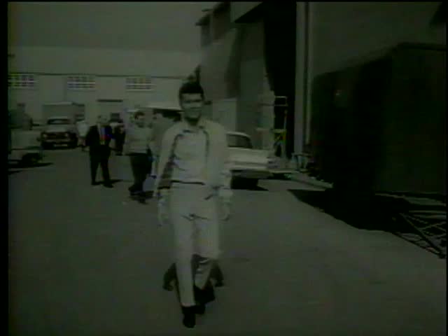 James Darren walks towards actors looking at Chrysler turbine engined car in Universal City, CA circa 1964-MGM PICTURES, UNIVERSAL-INTERNATIONAL NEWSREEL, USA, filmed in 1964
