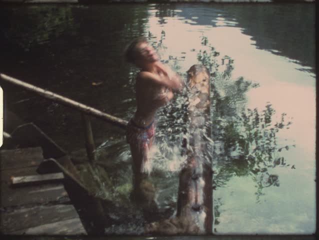 Vintage 8mm film: Boy riding on log
