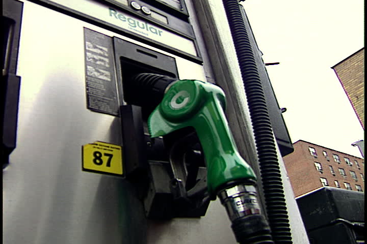 NEW YORK CITY - SEPTEMBER 29, 1999: A person's hand reaches over and takes gas pump from its cradle, and moves lever up to start filling tank.