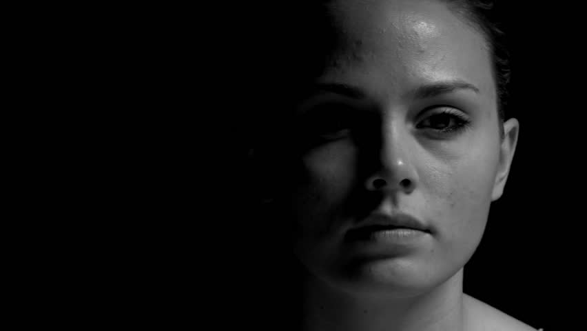 Dolly shot of woman in black and white. Experimental lighting.