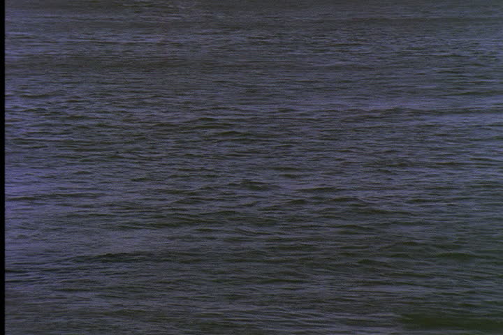 IMPERIAL VALLEY, CALIFORNIA - CIRCA JUNE 1996: Wide shot of water in All American Canal with hydroelectric wires passing over.
