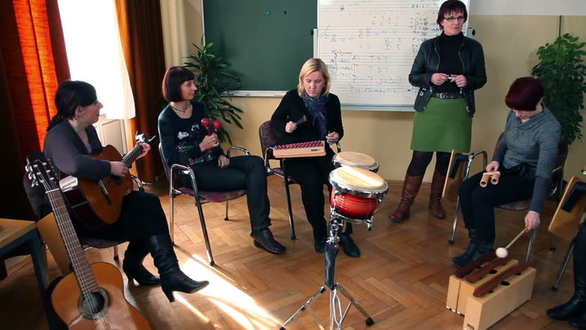 Right to left pan shot of the group of people that are learning a new song
