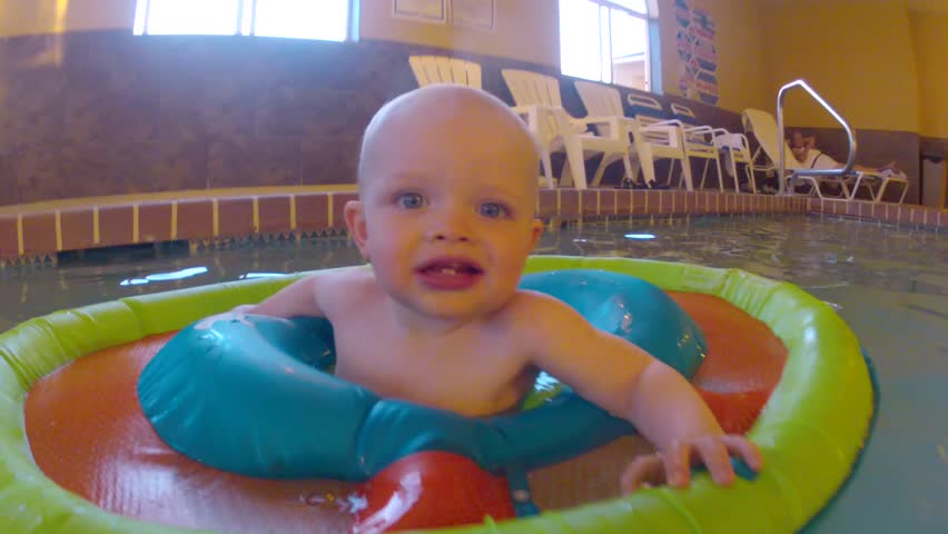 Underwater shot of a cute little baby boy at the swimming pool with his family.