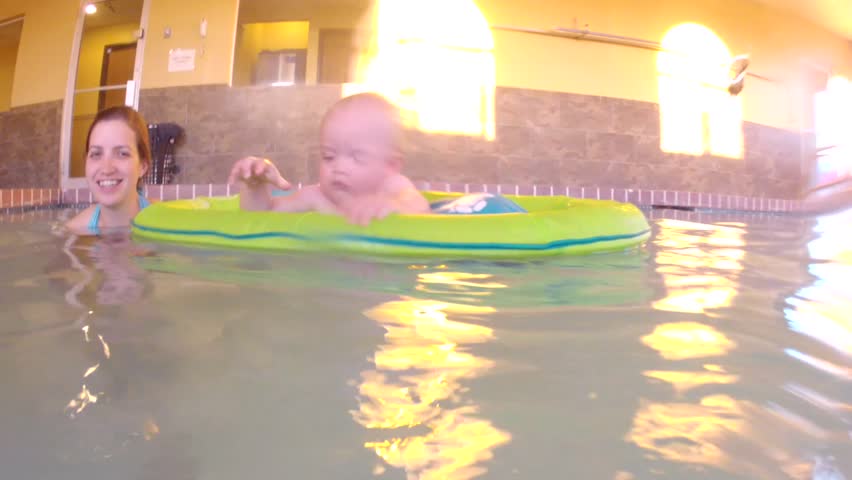 Underwater shot of a cute little baby boy at the swimming pool with his family.