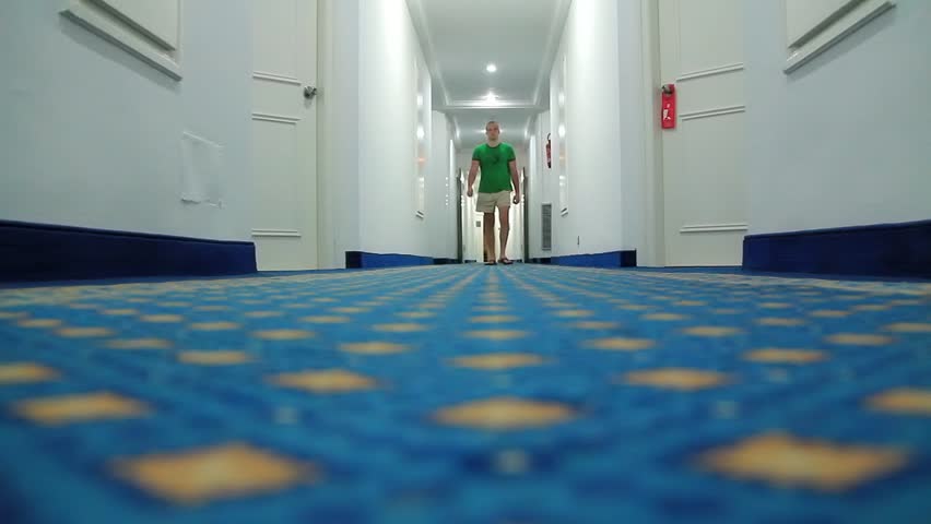 Man walking down a hotel corridor