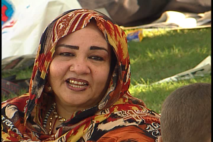 DUBAI - NOVEMBER 02, 2001: General views of Jebel Ali Race Course; CU Muslim woman in bright red patterned head scarf, smiling and laughing.