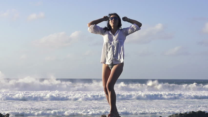 Happy, excited woman standing by the sea, super slow motion, shot at 240fps
