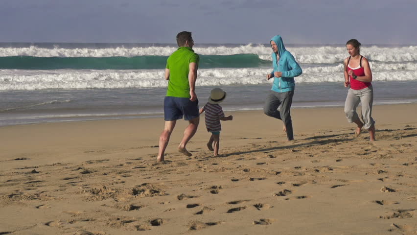 Father, son and joggers on the beach
