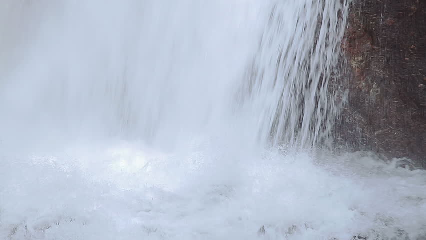 Forest waterfall detail, water splashing while falling over rocks