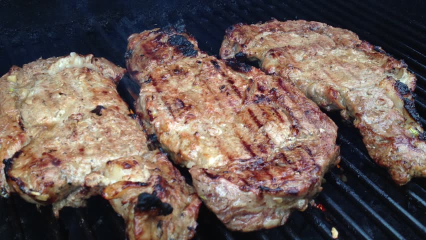 Three Prime Rib Steaks Grilled on a BBQ