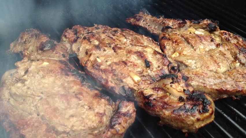 Three Prime Rib Steaks Grilled on a BBQ