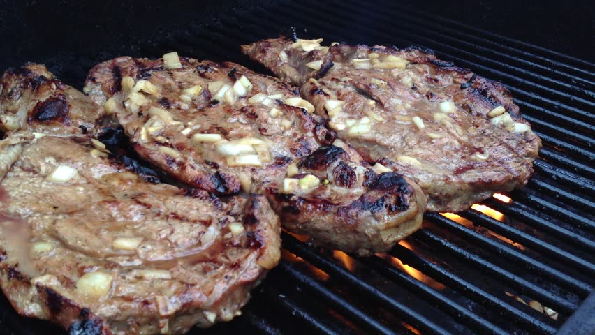 Three Prime Rib Steaks Grilled on a BBQ