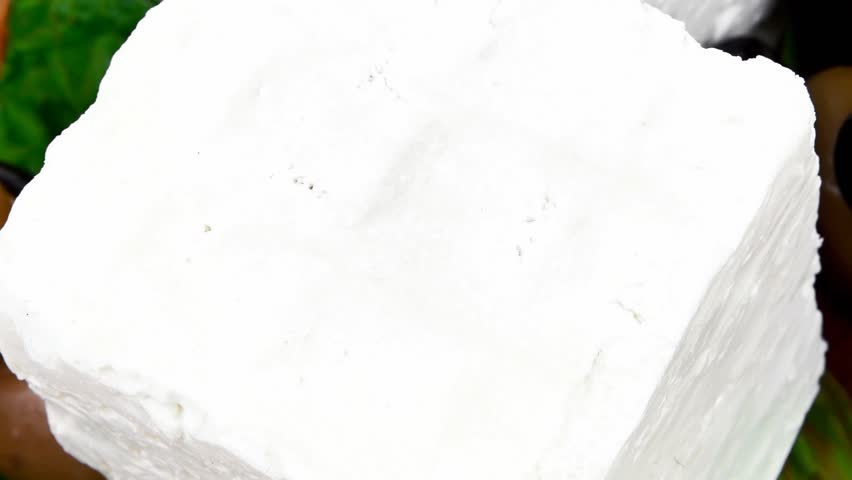 dairy food : feta white cheese cubes and round served on wooden cut plate with green leaves and olive oil 1920x1080 intro motion slow hidef hd