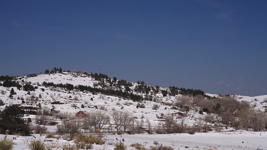 Cars travel on a country road in the snowy foothills near Boulder Colorado.