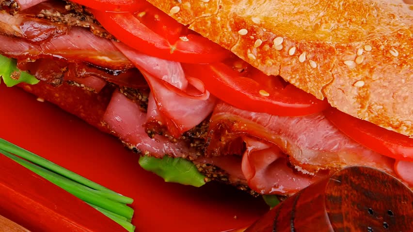 french sandwich : fresh white baguette with chicken smoked sausage on red ceramic plate over wooden table 1920x1080 intro motion slow hidef hd