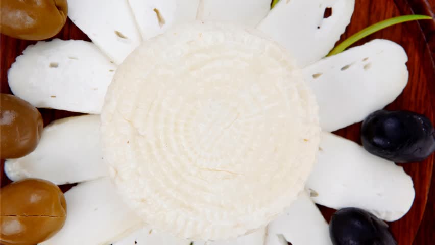 dairy products : feta white cheese sliced on cut board with olives and basil leaves 1920x1080 intro motion slow hidef hd